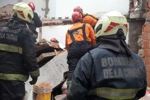 Bomberos trabajan para rescatar al obrero que quedó atrapado.