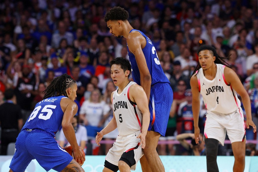 Paris 2024 Olympics - Basketball - Men's Group Phase - Group B - Japan vs France - Lille, Pierre Mauroy Stadium, Villeneve-d'Ascq, France - July 30, 2024. Victor Wembanyama of France (222cm/7'3'') the tallest player in the tournament in action with Yuki Togashi of Japan (167cm/5'66'') the shortest REUTERS/Brian Snyder