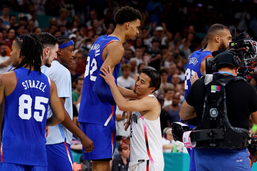 Paris 2024 Olympics - Basketball - Men's Group Phase - Group B - Japan vs France - Lille, Pierre Mauroy Stadium, Villeneve-d'Ascq, France - July 30, 2024. Victor Wembanyama of France (222cm/7'3'') the tallest player in the tournament shakes hands with Yuki Togashi of Japan (167cm/5'66'') the shortest after the match REUTERS/Brian Snyder