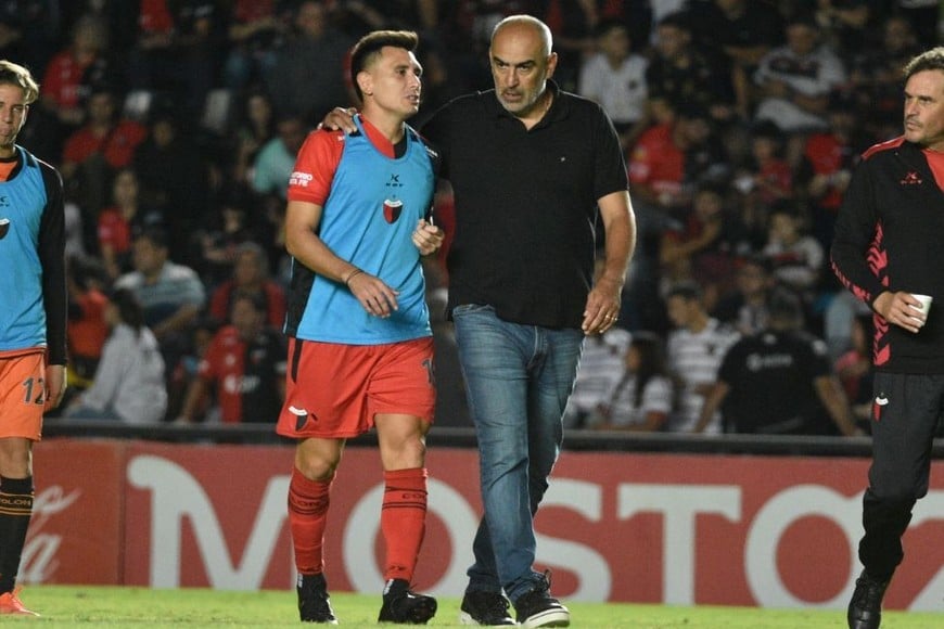 Acá no podía jugar. La postal de Cristian Vega, con la pechera suplente, dialogando con Iván Raúl Delfino. Más allá de sus condiciones técnicas y las opiniones futboleras, el "Kily" nunca se acomodó a Colón, ni en Primera División y mucho menos en la "B". Restan detalles pero se irá a jugar al club de toda su vida (diez temporadas seguidas y casi 200 partidos profesionales): Central Córdoba de Santiago del Estero. Crédito: Manuel Fabatía.