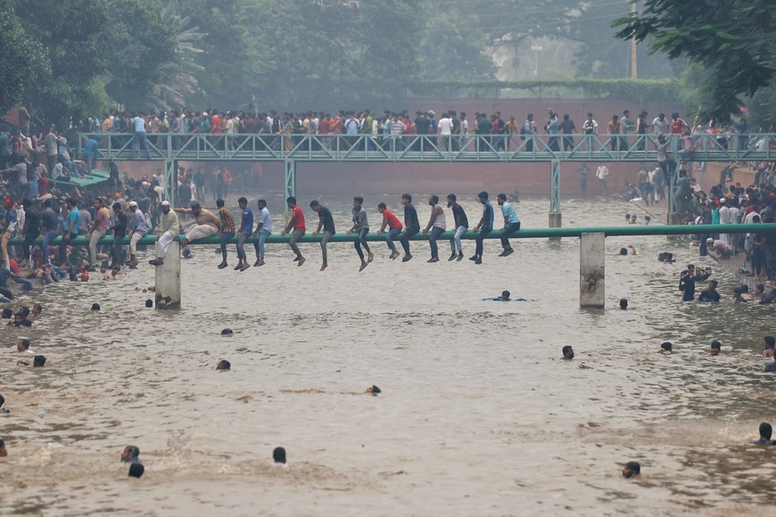 People swim in the lake inside Ganabhaban, the Prime Minister's residence, after the resignation of the Sheikh Hasina in Dhaka, Bangladesh, August 5, 2024. REUTERS/Mohammad Ponir Hossain TPX IMAGES OF THE DAY