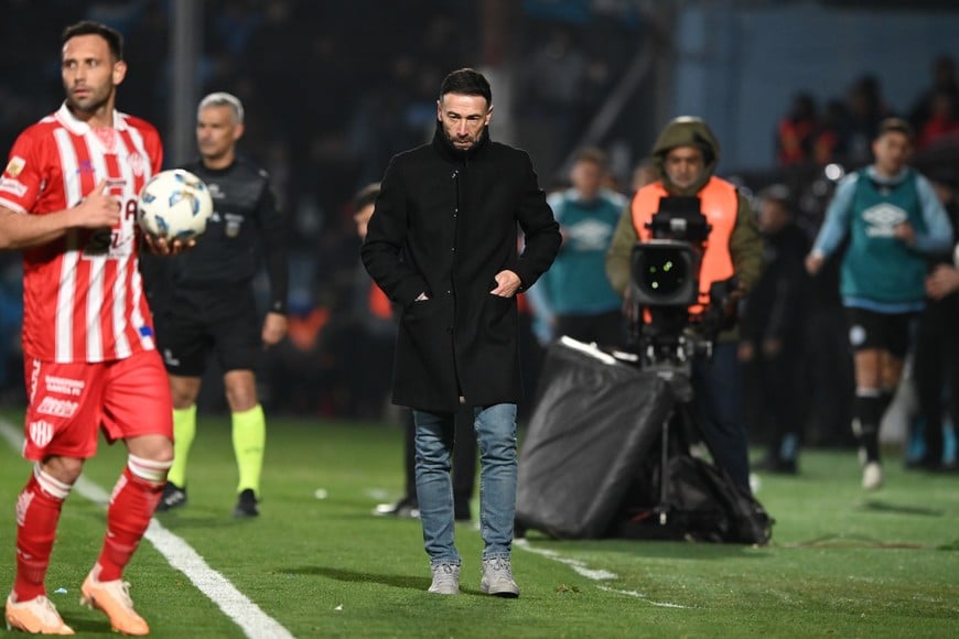 Claudio Corvalán con la pelota para efectuar un lateral y el Kily observando y viviendo el partido con su habitual concentración e intensidad. Unión buscará seguir encaramado en la punta ante un rival que llega conflictuado. Crédito: Ariel Carreras