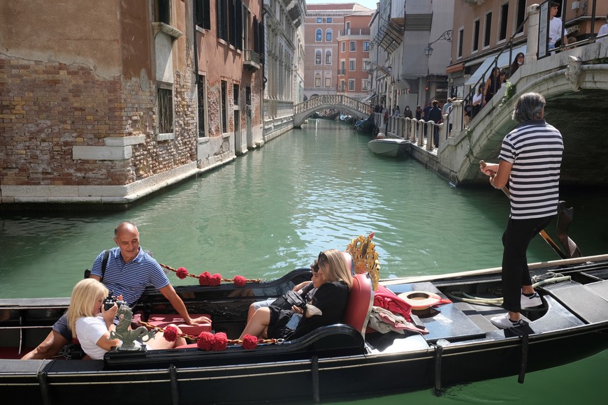 Tourists ride on a gondola as the municipality prepares to charge them up to 10 Euros for entry into the lagoon city, in order to cut down the number of visitors, in Venice, Italy, September 5, 2021. Picture taken September 5, 2021. REUTERS/Manuel Silvestri