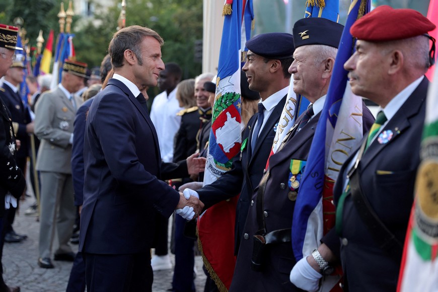 French President Emmanuel Macron greets veterans after a ceremony to commemorate the 80th anniversary of the Liberation of Paris next to the Denfert Rocherau Square in Paris, France, August 25, 2024. Teresa Suarez/Pool via REUTERS