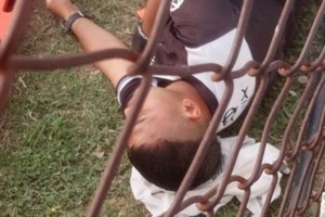 El juez de línea yace al costado del campo de juego, en Desvío Arijón, luego de la agresión que sufriera. Fue el último domingo.