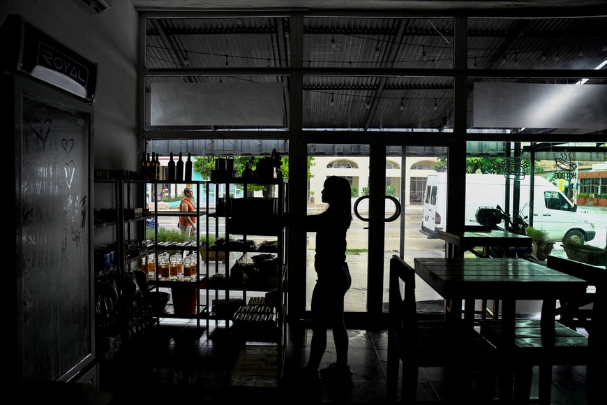 FILE PHOTO: A woman works in a restaurant during a blackout in Havana, Cuba, October 17, 2024. REUTERS/Norlys Perez/File Photo