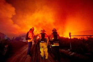Firefighters watch as the Franklin Fire burns in Malibu, California, U.S., December 10, 2024. REUTERS/Ringo Chiu