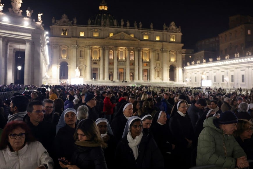 People stand together as they gather to see Pope Francis pass, at the Vatican, December 31, 2024. REUTERS/Claudia Greco