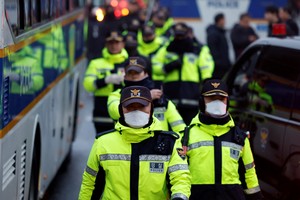 Police officers walk near the official residence of the impeached South Korean President Yoon Suk Yeol in Seoul, South Korea, January 6, 2025. REUTERS/Tyrone Siu
