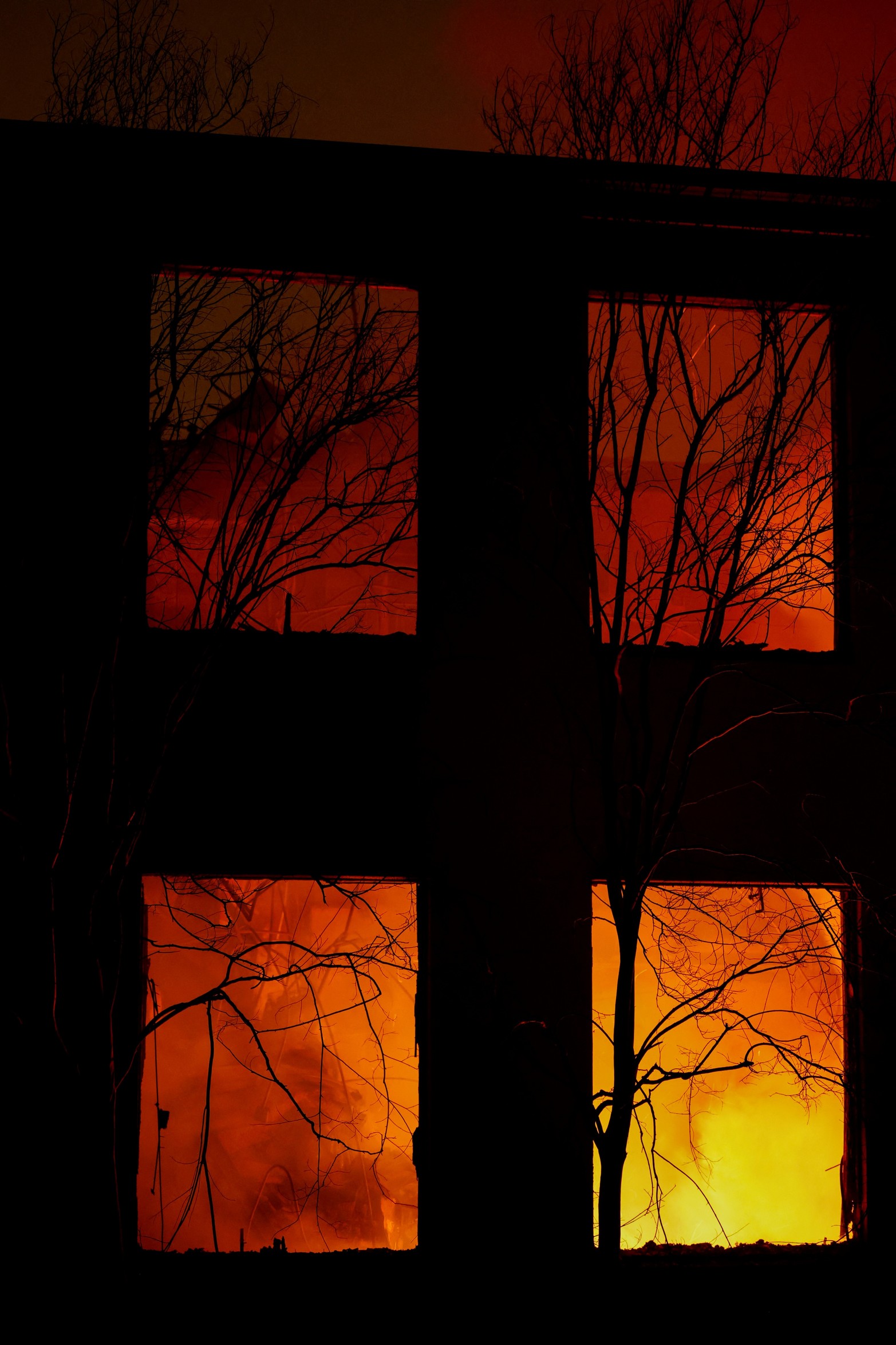 Las llamas se ven a través de una ventana de un edificio en llamas. Créditos: Fred Greaves/Reuters
