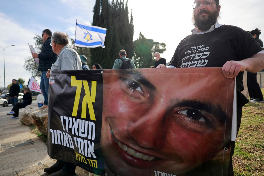 Families and supporters of Israeli hostages kidnapped during the deadly October 7, 2023 attack by Hamas, hold a banner as they gather to demand a deal that will bring back all the hostages held in Gaza, outside a meeting between hostage representatives and Israeli Prime Minister Benjamin Netanyahu, in Jerusalem, January 14, 2025. REUTERS/Ammar Awad