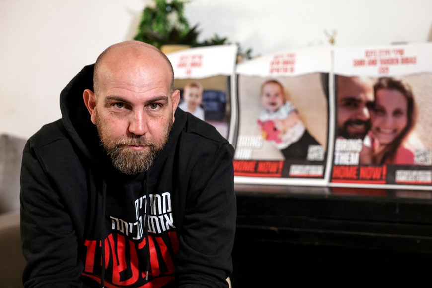 Yosi Shnaider, the cousin of Shiri Bibas, who was taken hostage, along with her children Kfir, 9-months-old when taken, Ariel, 4, and her husband Yarden, speaks to Reuters during an interview from his home in Holon, Israel, December 4, 2023. REUTERS/Ronen Zvulun