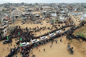 A drone view shows Palestinians and militants gathering around Red Cross vehicles on the day Hamas hands over the bodies of deceased hostages Oded Lifschitz, Shiri Bibas and her two children Kfir and Ariel Bibas, seized during the deadly October 7, 2023 attack, as part of a ceasefire and hostages-prisoners swap deal between Hamas and Israel, in Khan Younis in the southern Gaza Strip, February 20, 2025. REUTERS/Stringer     TPX IMAGES OF THE DAY