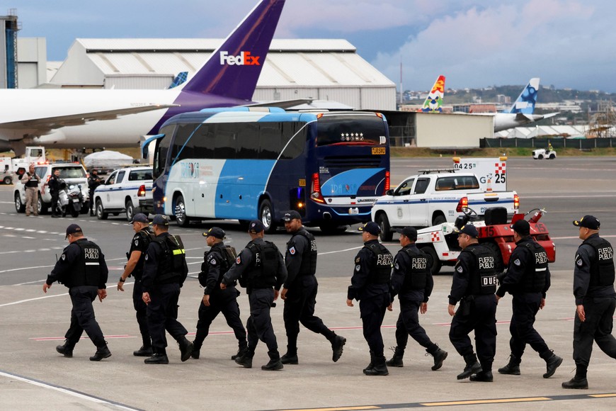 Law enforcement officers walk as buses carrying migrants who arrived in Costa Rica on a deportation flight from the U.S. leave Juan Santamaria International Airport, in Alajuela, Costa Rica, February 20, 2025. REUTERS/Mayela Lopez