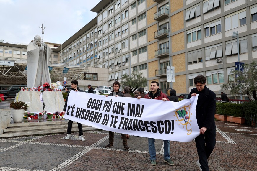 Members of Christian workers movement hold a banner that reads: "Today more than ever we need you Francis!" outside Gemelli Hospital, where Pope Francis is admitted for treatment, in Rome, Italy, February 25, 2025. REUTERS/Claudia Greco