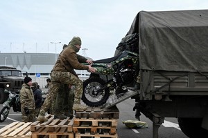 Participants load motorcycles into a truck during a ceremony to hand over new motocross bikes to the Russian military involved in a military conflict against Ukraine, in the parking lot near a football stadium in Rostov-on-Don, Russia, November 28, 2024. REUTERS/Sergey Pivovarov