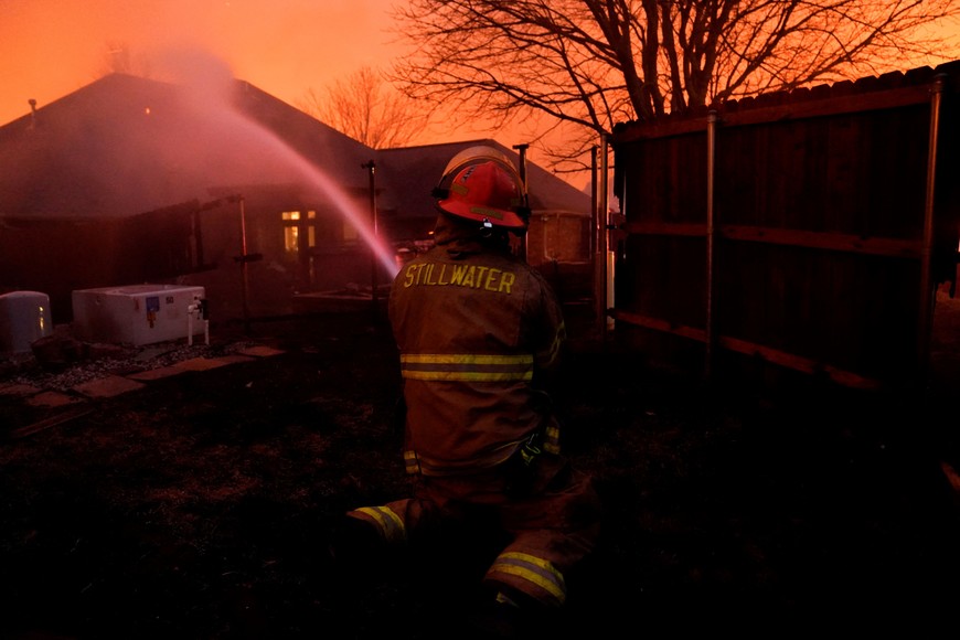 A firefighter works to extinguish fire during a wildfire outbreak in Stillwater, Oklahoma, U.S., March 14, 2025.  REUTERS/Nick Oxford