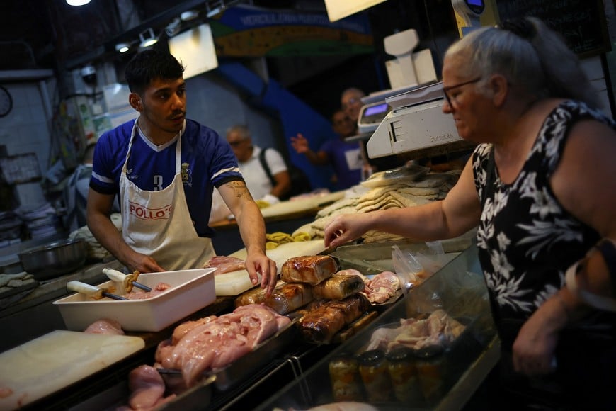 A butcher talks to a costumer in a local market, as Argentines ate more poultry per capita than beef in 2024, official data show that consumption of the red meat slid amid high inflation and tough austerity under libertarian President Javier Milei, in Buenos Aires, Argentina January 23, 2025. REUTERS/Agustin Marcarian