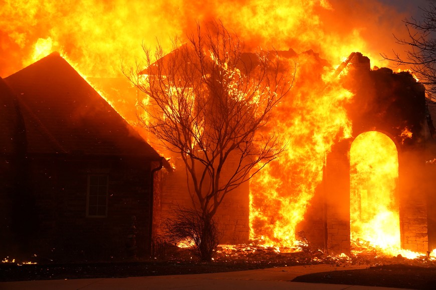 Fire burns a residence during a wildfire outbreak in Stillwater, Oklahoma, U.S., March 14, 2025.  REUTERS/Nick Oxford