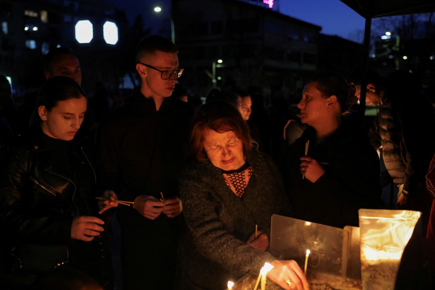 A woman reacts as people light candles in memory of the victims of a fire in a night club in the town of Kocani, North Macedonia, March 16, 2025. REUTERS/Alexandros Avramidis