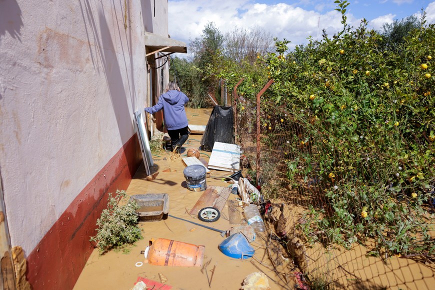 A woman walks during floods following the overflowing of Guadalhorce River due to heavy rains, as storm Laurence hits Spain, in Cartama, Spain, March 18, 2025. REUTERS/Jon Nazca