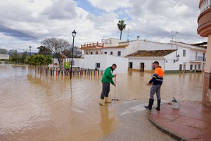 Men clean the street outside their houses while the Guadalhorce River overflows after heavy rains, as storm Laurence hits Spain, in Cartama, Spain, March 18, 2025. REUTERS/Jon Nazca
     TPX IMAGES OF THE DAY