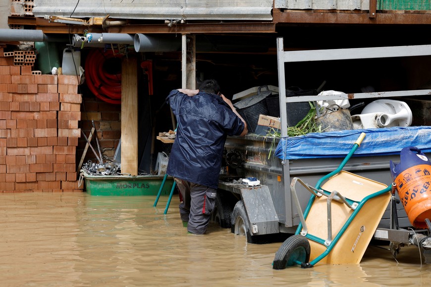 A man checks his house following the overflowing of Guadalhorce River due to heavy rains, as storm Laurence hits Spain, in Cartama, Spain, March 18, 2025. REUTERS/Jon Nazca