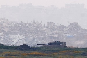An Israeli tank manoeuvres inside Gaza, infront of destroyed buildings, as viewed from the Israel-Gaza border, March 20, 2025. REUTERS/Amir Cohen