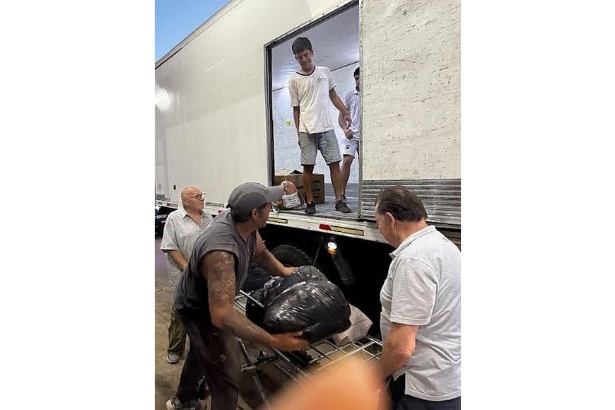 Directivos de Bomberos y colaboradores, durante el trabajo de carga del camión.