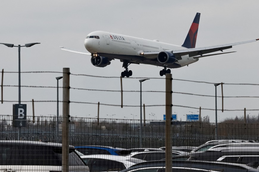 A passenger plane makes its landing approach to Heathrow International Airport, a day after a fire at a nearby electrical substation wiped out power at the airport, near London, Britain, March 22, 2025. REUTERS/Carlos Jasso