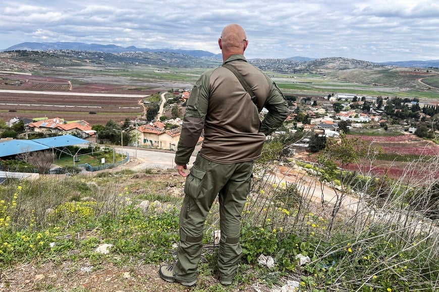 An Israeli soldier stands above the Israeli border town of Metula, just by the Israel-Lebanon border on its Israeli side, near Metula, Israel March 22, 2025.REUTERS/Avi Ohayon