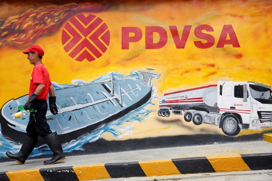 FILE PHOTO: A worker walks past a mural with a PDVSA logo at its gas station in Caracas August 29, 2014. Venezuela's state-run PDVSA has put on hold its plans to export diluted crude oil (DCO) in October as the company reviews production costs that have risen on imports of costly naphtha that it uses to mix with its extra heavy crude, traders told Reuters on Friday. REUTERS/Carlos Garcia Rawlins (VENEZUELA - Tags: ENERGY POLITICS BUSINESS LOGO)/File Photo