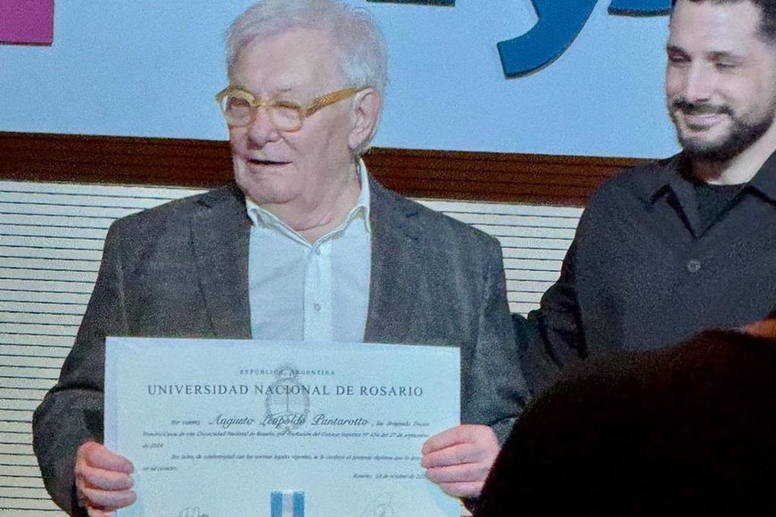 El arquitecto Augusto Pantarotto recibe la distinción de manos de autoridades de la UNR, durante el acto realizado en la FAPyD.