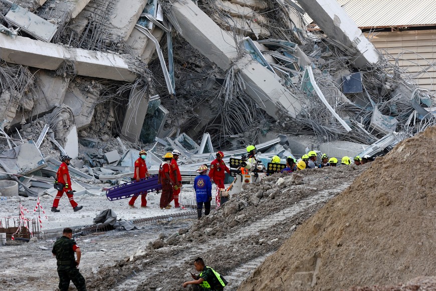 Rescue personnel work near a building that collapsed after a strong earthquake struck central Myanmar on Friday, earthquake monitoring services said, which affected Bangkok as well with people pouring out of buildings in the Thai capital in panic after the tremors, in Bangkok, Thailand, March 28, 2025. REUTERS/Athit Perawongmetha
