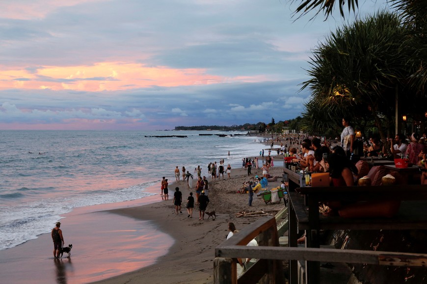 FILE PHOTO: Tourists enjoy the sunset at Canggu beach amidst the coronavirus disease (COVID-19) pandemic in Bali, Indonesia, December 2, 2021. REUTERS/Johannes P. Christo/File Photo