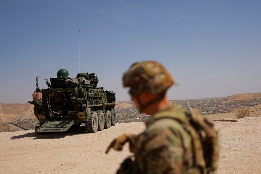 A U.S. Army member stands guard near a Stryker armored vehicle at the U.S.-Mexico border in Sunland Park, New Mexico, U.S., March 28, 2025. REUTERS/Jose Luis Gonzalez