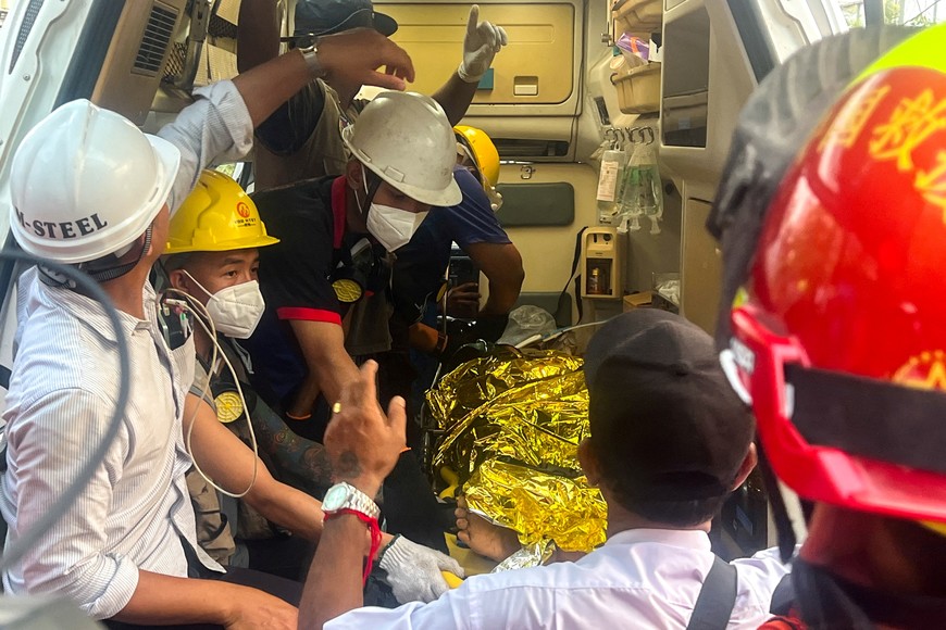 Chinese rescue workers carry a survivor trapped inside the Golden Country Hotel following a strong earthquake in Mandalay, Myanmar, April 2, 2025. REUTERS/Stringer