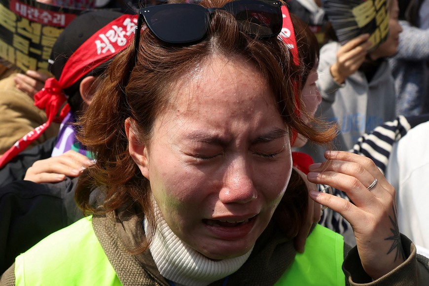 A woman reacts as people celebrate after President Yoon Suk Yeol's impeachment was accepted, near the Constitutional Court in Seoul, South Korea, April 4, 2025.   REUTERS/Kim Hong-ji