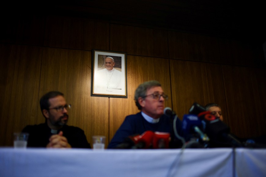 A picture of Pope Francis hangs on a wall behind Archbishop of Buenos Aires Jorge Ignacio Garcia Cuerva during a press conference, after the death of Pope Francis was announced by the Vatican, in Buenos Aires, Argentina, April 21, 2025. REUTERS/Agustin Marcarian