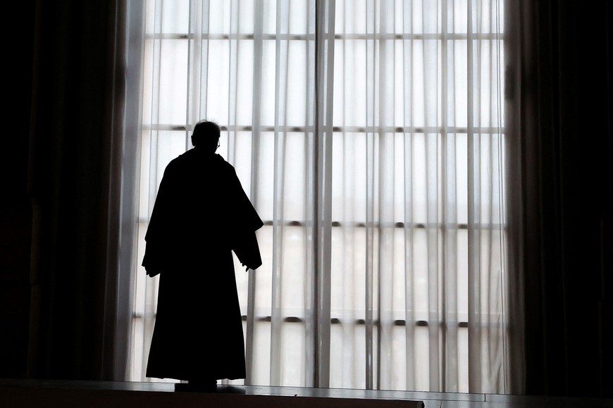 Father Bruno Silvestrini stands at a balcony door of the Loggia delle Benedizioni (Loggia of Blessings), as Pope Francis lies in state in St. Peter's Basilica, at the Vatican, April 25, 2025. REUTERS/Claudia Greco