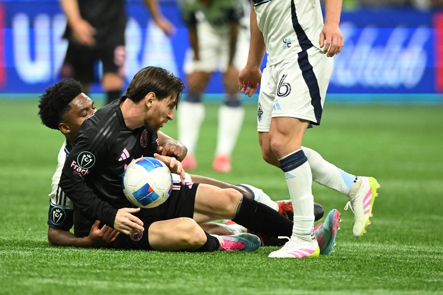 Apr 24, 2025; Vancouver, British Columbia, CAN;   Vancouver Whitecaps FC midfielder Ralph Priso (13) fights for the ball against Inter Miami SC forward Lionel Messi (10)during the second half at BC Place. Mandatory Credit: Anne-Marie Sorvin-Imagn Images