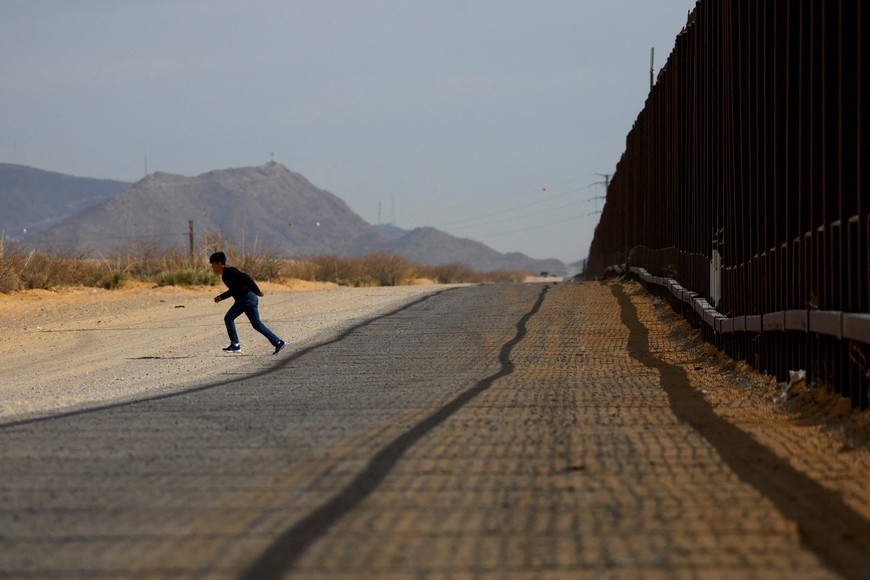 A migrant runs, after entering the United States undetected through a hole in a section of the U.S.-Mexico border wall, in Sunland Park, New Mexico, U.S., January 28, 2025. REUTERS/Jose Luis Gonzalez     TPX IMAGES OF THE DAY