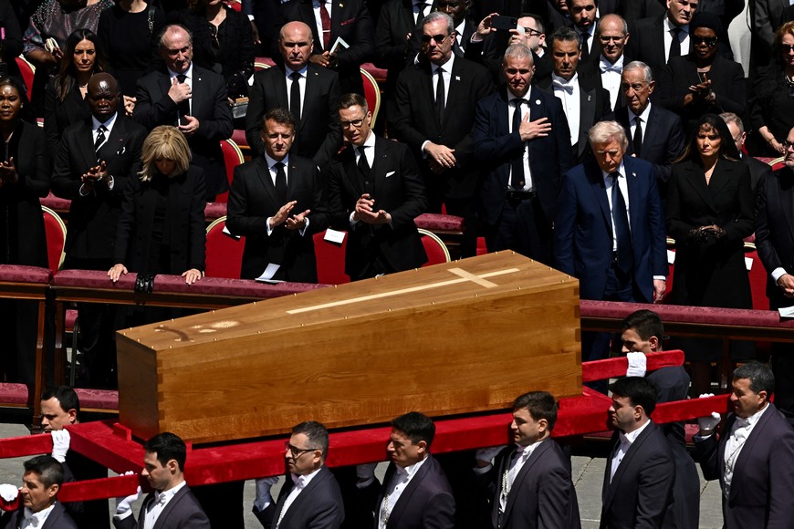 U.S. President Donald Trump, first lady Melania Trump, France's President Emmanuel Macron and his wife Brigitte Macron watch as the coffin of Pope Francis is carried by pallbearers during his funeral Mass in St. Peter's Square at the Vatican, April 26, 2025. REUTERS/Dylan Martinez