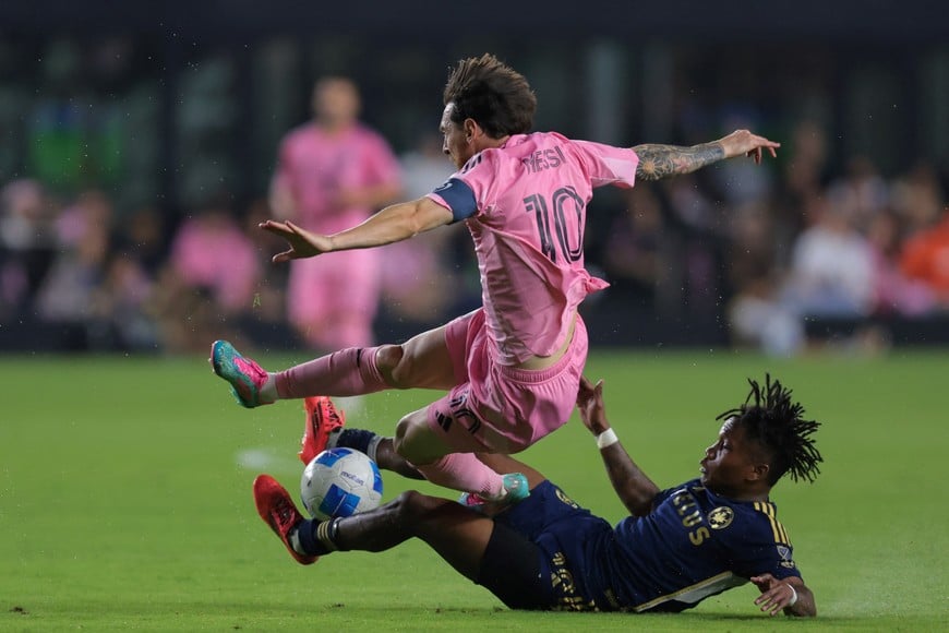 Apr 30, 2025; Ft. Lauderdale, Florida, USA; Inter Miami CF forward Lionel Messi (10) dribbles the ball as Vancouver Whitecaps defender Edier Ocampo (18) dives for a challenge during the first half at Chase Stadium. Mandatory Credit: Sam Navarro-Imagn Images