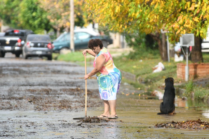 Una vecina de Barranquitas saca la hojarasca otoñal, que no ayudó con la lluvia.