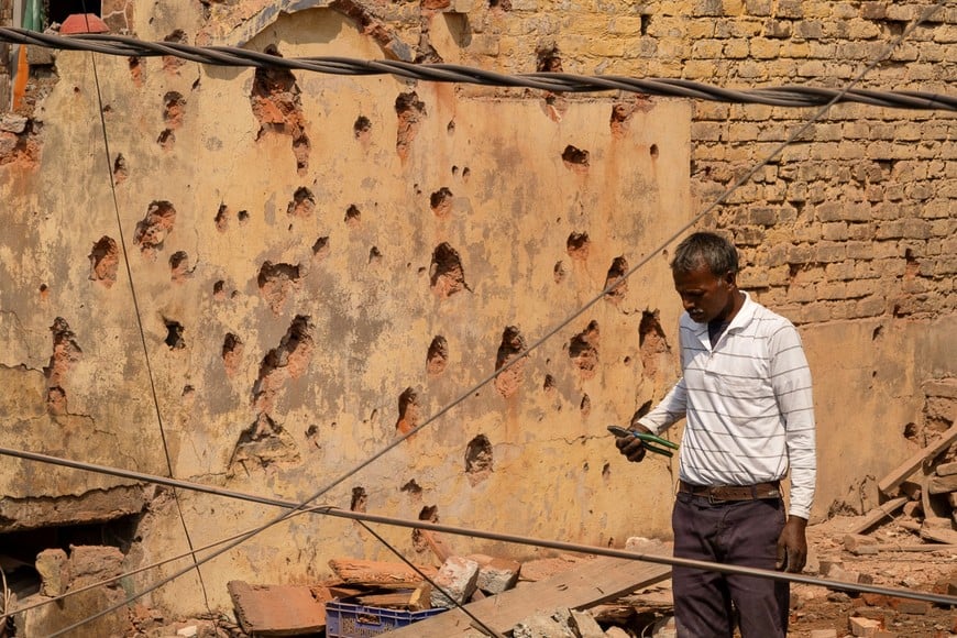 A man stands amidst the debris on the roof of a damaged house, following Pakistan's military operation against India, in Rehari, Jammu, May 10, 2025. REUTERS/Adnan Abidi