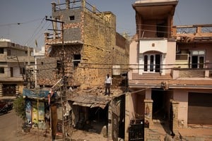 A man stands amidst the debris on the roof of a damaged house, following Pakistan's military operation against India, in Rehari, Jammu, May 10, 2025. REUTERS/Adnan Abidi