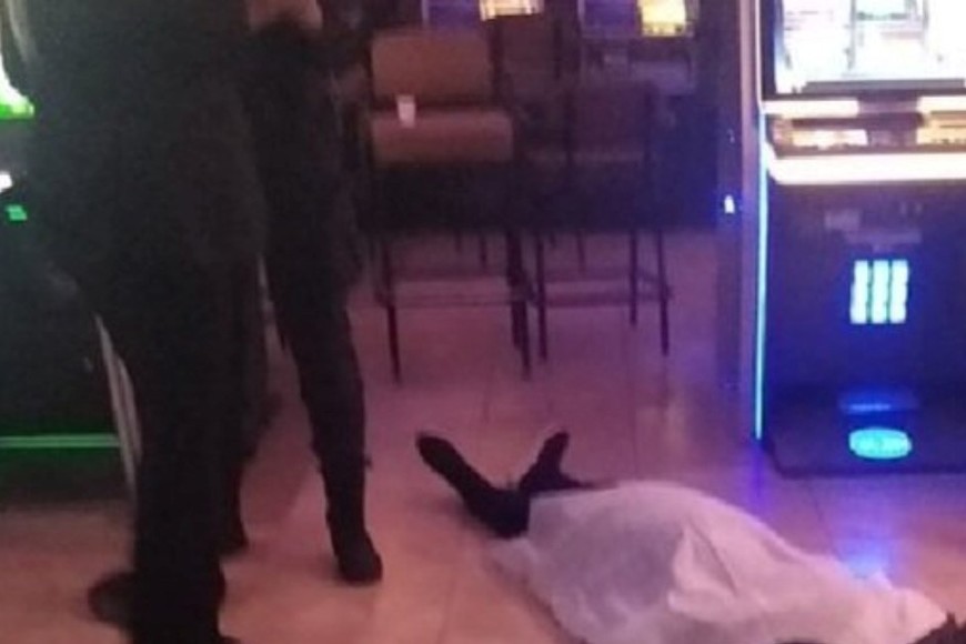 Imagen sensible. El cuerpo cubierto de la mujer fallecida dentro de la sala de juegos.