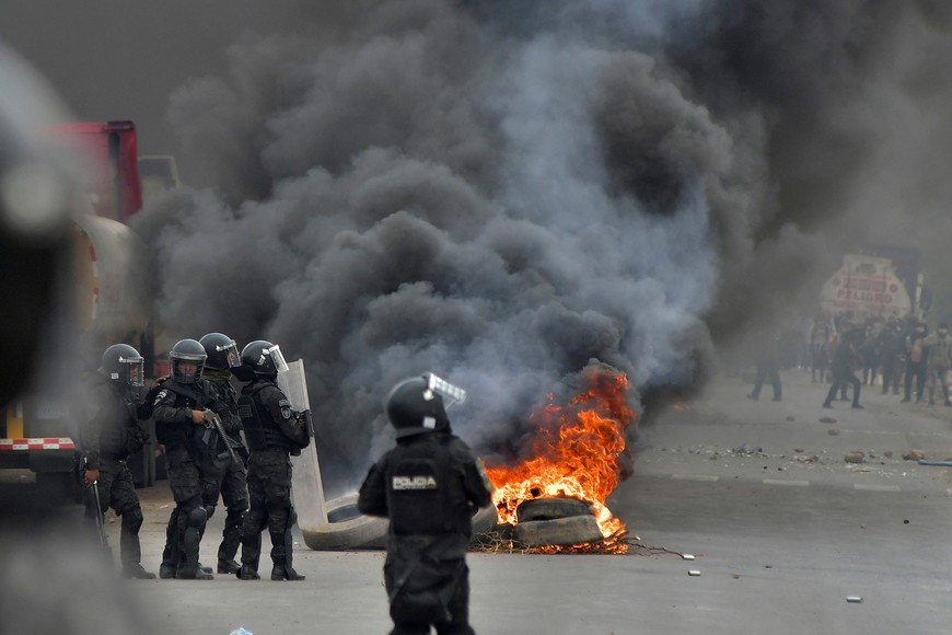 Police operate near a burning barricade as they attempt to dismantle a blockade set by supporters of Bolivia's former President Evo Morales in protest of the government of President Luis Arce, in Parotani, Bolivia October 25, 2024. REUTERS/Patricia Pinto