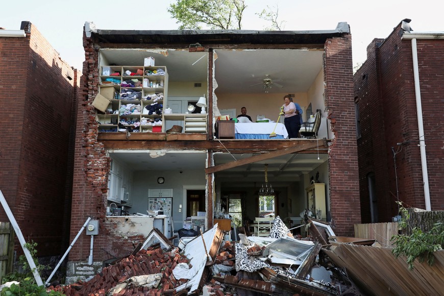 Residents inspect their home after a tornado completely tore off the back wall of a two-story house in St. Louis, Missouri,U.S. May 16, 2025. REUTERS/Lawrence Bryant